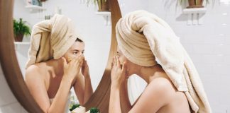 Young Woman Applying Cream to Face