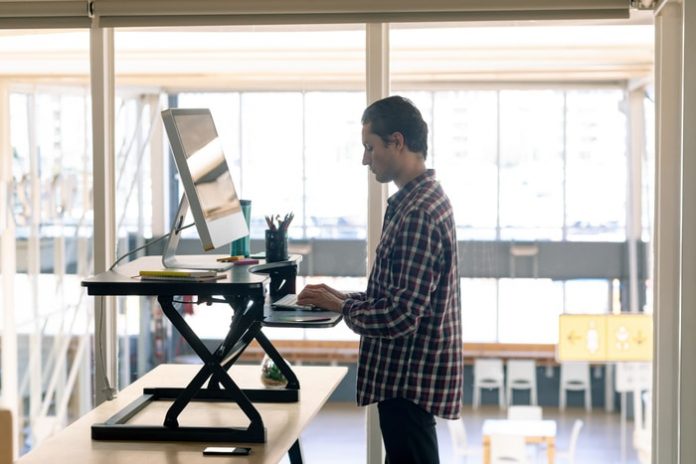 employee-working-on-standing-desk Employee Working on Standing Desk
